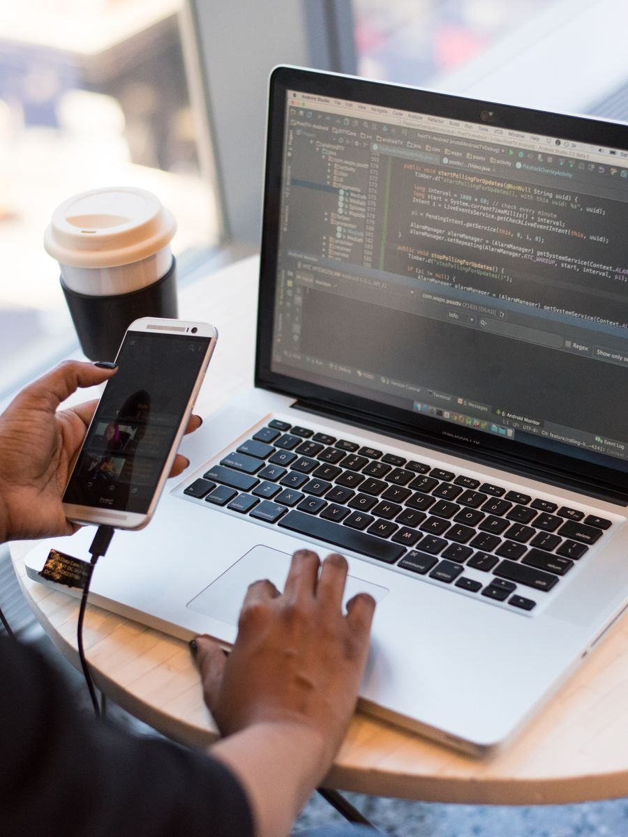 Laptop on a desk with programming code on the screen
